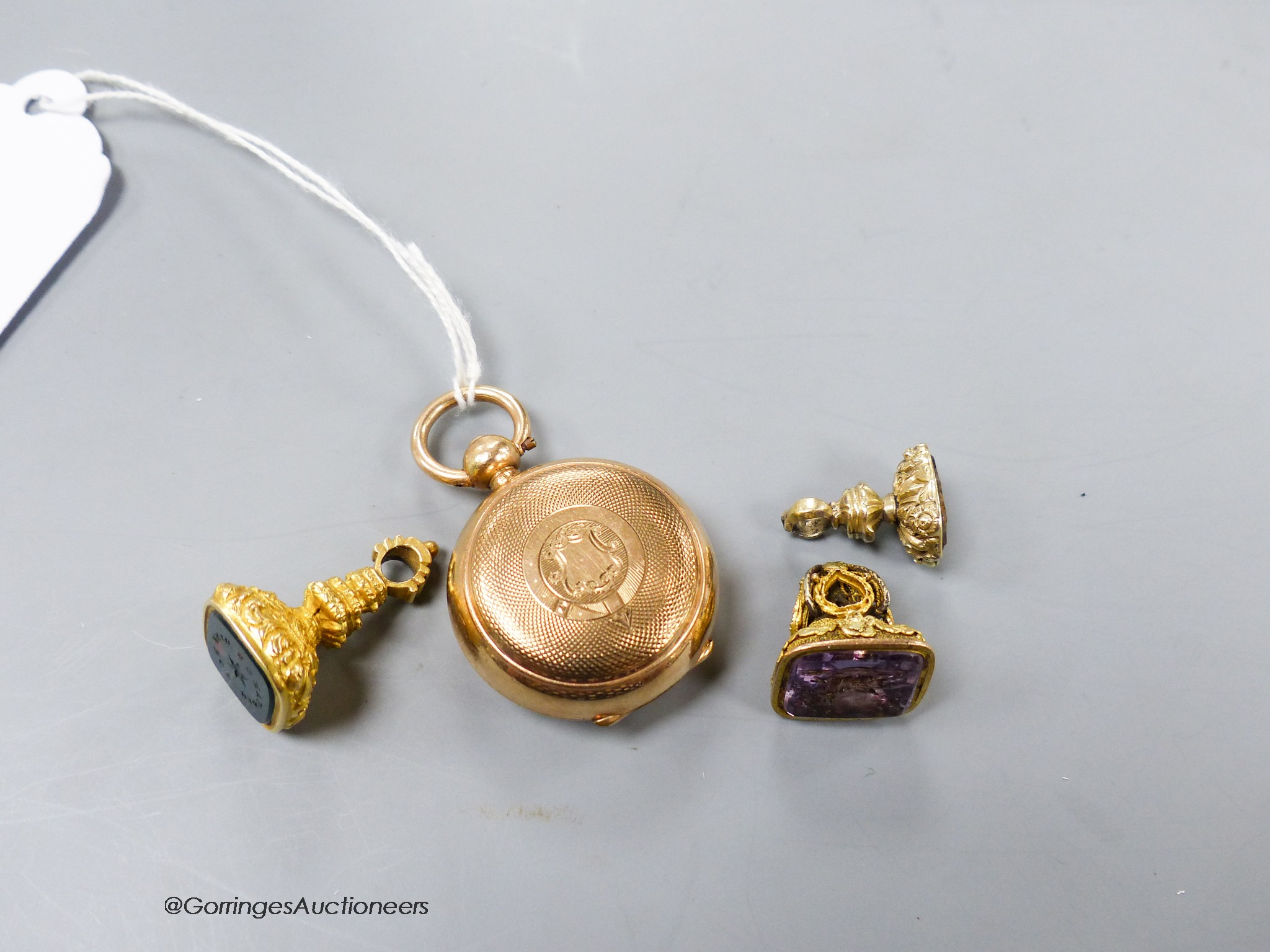 A gold plated sovereign case and three assorted yellow metal overlaid and gem set fob seals (one a.f.) including two with carved matrix, largest 26mm.